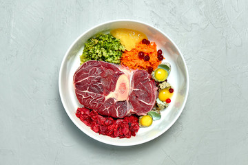Healthy natural dog food in a bowl over grey background. 