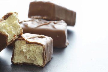 Chocolate bars on a black background in backlight. Chocolate with filling. Sweet sweets for snack and tea.