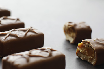 Chocolate bars on a black background in backlight. Chocolate with filling. Sweet sweets for snack and tea.