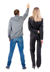 Back view of a stylish couple pointing.