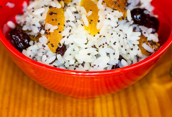 handmade preparation of treats for traditional Orthodox Christmas - rice pudding with fruits, cranberries, honey, nuts, Church candles