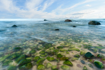 A view of the rocky beach in Miedzyzdroje. Baltic sea. Stones into the water. Blurry effect with long exposure.