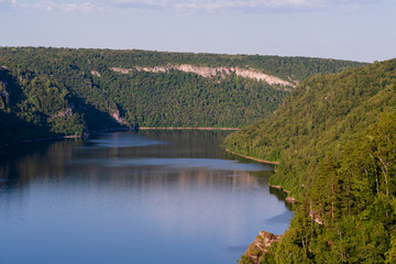 Obraz premium Blue lake in the middle of mountains and forests at sunset.