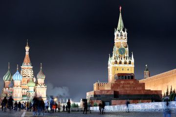 Fototapeta na wymiar moscow kremlin russia famous russian architecture landmark at night against black sky background. Street view of people walking along red square towards saint basil cathedral. Moscow city skyline