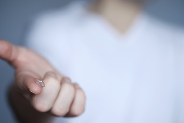 The concept of poor vision. Hold a contact lens and glasses in hand. A poster for advertising...