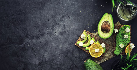 Avocado cooking recipes. Ripe green avocado on a wooden cutting board for serving.