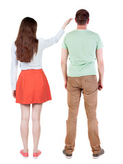 Back view of a stylish couple pointing.