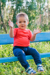 portrait of smiling little boy on the street. cute cheerful baby walking in the Park. happy child