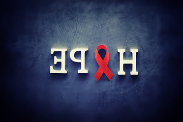 Symbol of human immunodeficiency virus disease. Red ribbon. A helping hand and support.