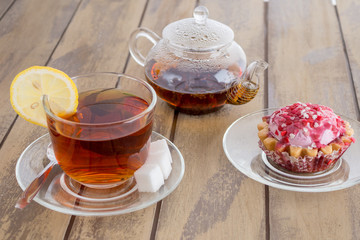 Tea in glass cup with lemon and mint on wooden background