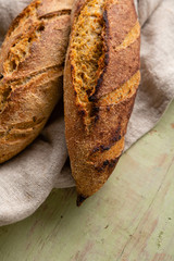 Two loaves of rye bread on wooden background