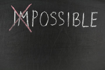 Impossible possible. Text on chalkboard. Inspirational quote
