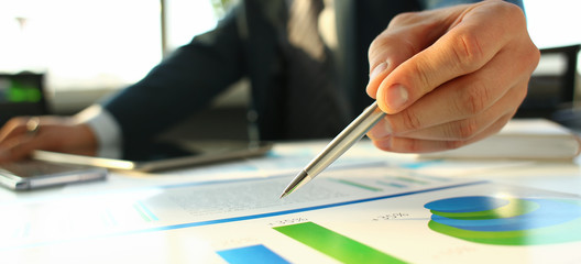 Hand of businessman in suit filling and signing with