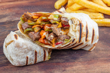 Tortilla wraps sandwiches with fresh vegetables, minced meat and served with french fries on...