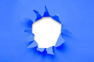 Breakthrough paper hole with white background toned with main trendy Classic Blue color of the year 2020. Place for text