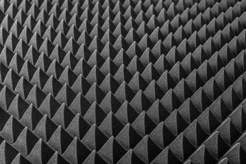 Abstract background in the form of pyramids and dragon scales. Acoustic black foam rubber.