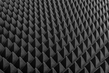 Abstract background in the form of pyramids and dragon scales. Acoustic black foam rubber.