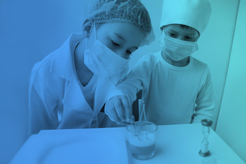 two boys in white medical uniforms, wearing protective masks and