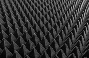 Abstract background in the form of pyramids and dragon scales. Acoustic black foam rubber.