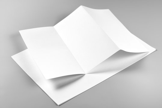 Blank Folded Flyer or Letterhead over Stack of Paper