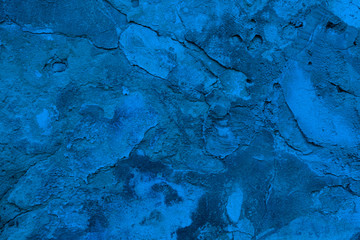 Old grunge concrete, dirty peeled plaster wall texture background. Trendy classic blue color toned background