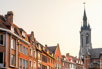 Tall medieval bell tower rising over the street with old european houses, Tournai, Walloon municipality, Belgium