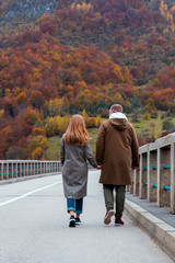 Сouple walks along the Durdevica Tara Bridge, Montenegro. The guy and the girl hold hands.