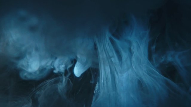 Paint brush is place in water. The artist draw picture. Paintbrush with acrylic blue ink dipped in liquid. Real visual effect fraction in form of cloud video magic and spray in liquid by drop.