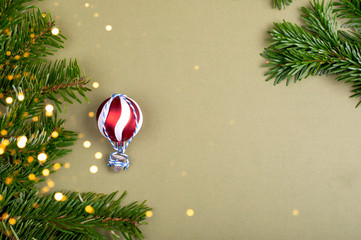 The air-balloon made of Christmas tree decoration ball. Pine tree branches on green background with...