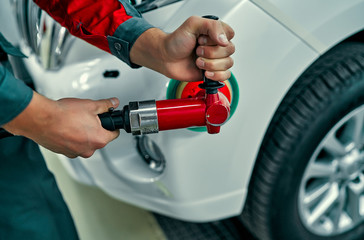 Close up image of auto mechanic buffing car autobody. Car repair and maintenance.
