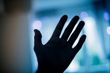 Rised hand with blue defocused background