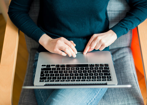 Overhead view of female hand working coding on new aluminum laptop computer usig the touchscreens mouse