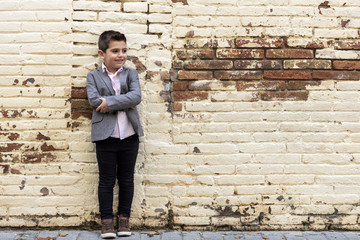 Fashion little kid with a brick wall background