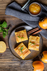 Sweet carrot pie topped with peach jam and persimmon pieces and sprinkled with cinnamon