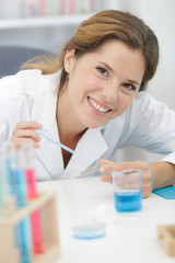 happy female chemist working in lab experimenting