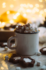 Comforting Christmas food, mug of hot cocoa with marshmallow and cookies with cozy lights