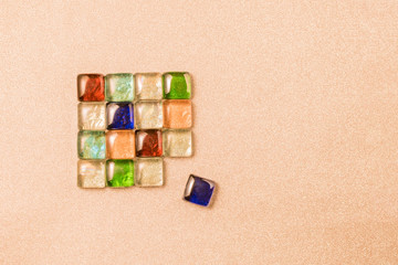 A figure on a pink background of colored stones