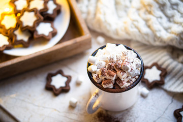 Fototapeta na wymiar Comforting Christmas food, mug of hot cocoa with marshmallow and cookies with cozy lights