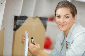 a woman is assembling a furniture door