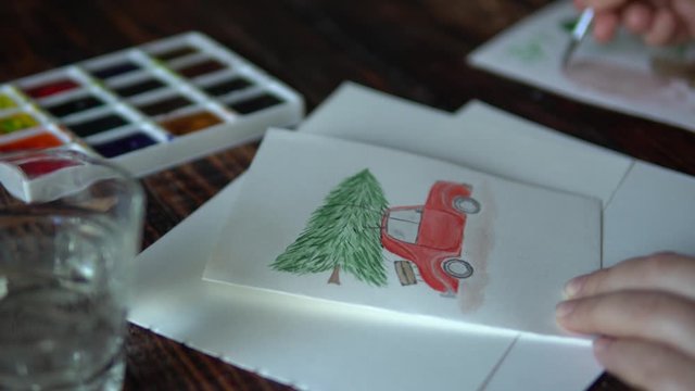 Woman painting red car with Christmas tree on the roof on the holiday postcard