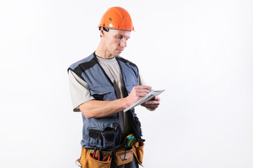 Builder with a notepad. In a helmet and a robe. Writes data.