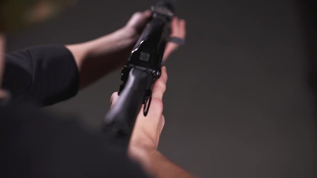 Slow-motion, Over the Shoulder View of Woman Raising AK Style Rifle Up to Shoulder With Proper Trigger Discipline