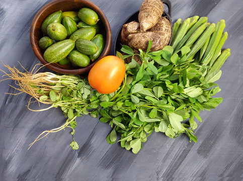 Indian vegetables of Tomatoes, carrots, Yams, Pointed gourd, Green chilies, Methi leaves, cilantro, and egg plants