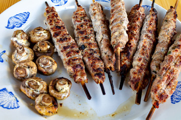 kebab of meat on skewers close-up, grilled mushrooms