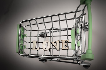shopping cart with the inscription love lined with letters, the concept of a love sensual, money...