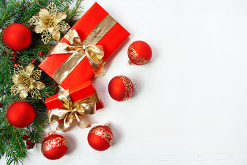 Christmas background - spruce branches, gifts, red and gold decorations on white background
