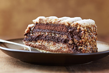 Piece of Chocolate Cake on plate. Rustic wooden background. Close up. 