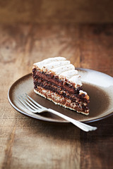 Piece of chocolate cake on rustic background.