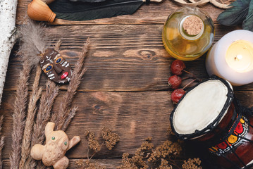 Shaman accessories and mask amulet on wooden table background with copy space. Magic table concept.