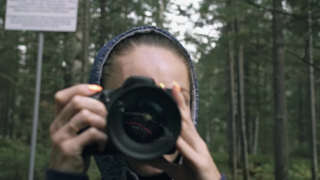 Traveler photographing scenic view in forest. One caucasian woman shooting close up look. Girl take photo video on dslr mirrorless camera. Professional photographer travel with backpack. Outdoor.